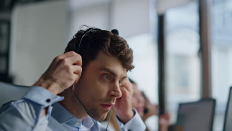 Agent-hand-taking-headset-from-monitor-closeup.-Friendly-hotline-manager-talking