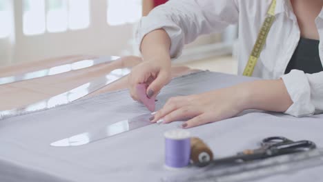 hand female fashion, designer, draws on a piece of fabrics