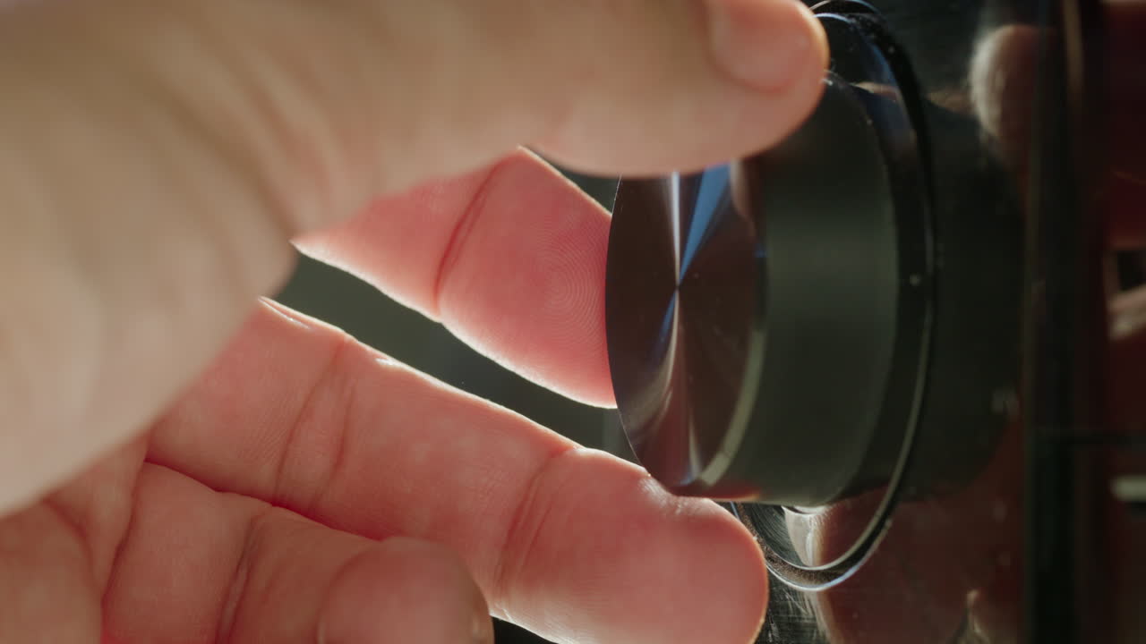 남자의 손은 볼 레벨을 조정하고, 수신기의 손잡이를 돌립니다.