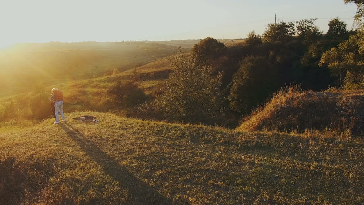 Couple Hold Each Other And Kiss. Aerial shot of a silhouetted couple hold each other and kiss on the nature