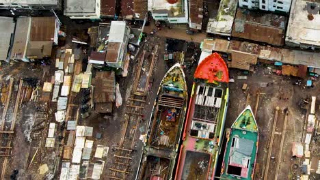 un astillero en asia con materiales de construcción y barcos que están siendo renovados