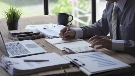 businessman developing business project and analyzing marketing graph data with accounting documents and financial reports on 4k video table.