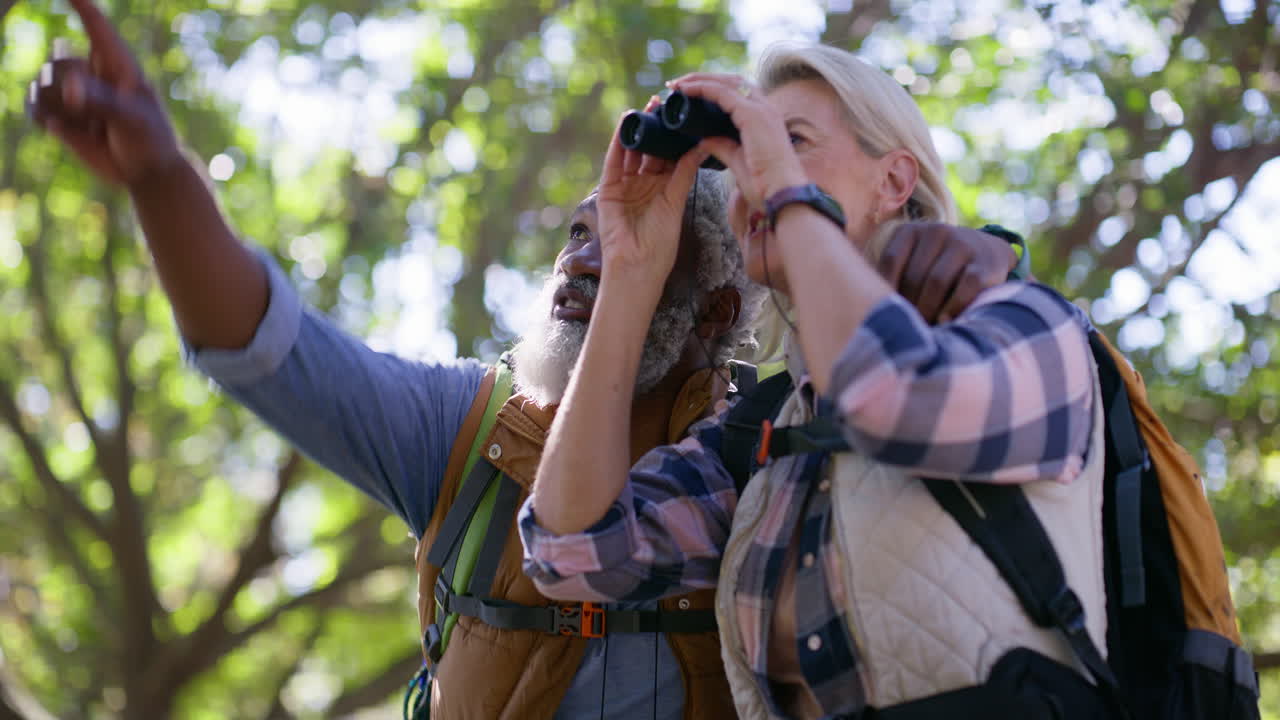 Senior Couple Hiking and Exploring Nature with Binoculars
