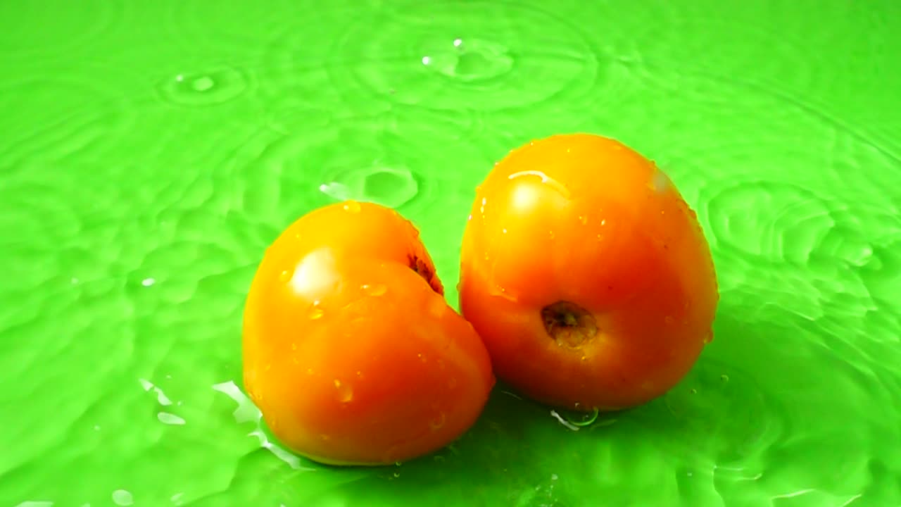Tomater falder i vand. Slowmotion
