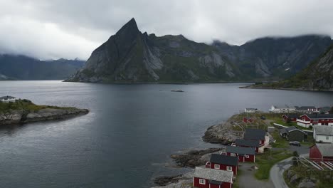 Volando-Sobre-El-Icónico-Pueblo-De-Pescadores-De-Hamnoy-En-Noruega,-Lofoten-Con-Vistas-A-Las-Montañas-Y-Al-Océano-Con-Gaviotas-Volando-Debajo-De-La-Cámara-Y-Sobre-El-Océano