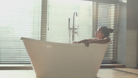 mujer relajándose en una bañera moderna