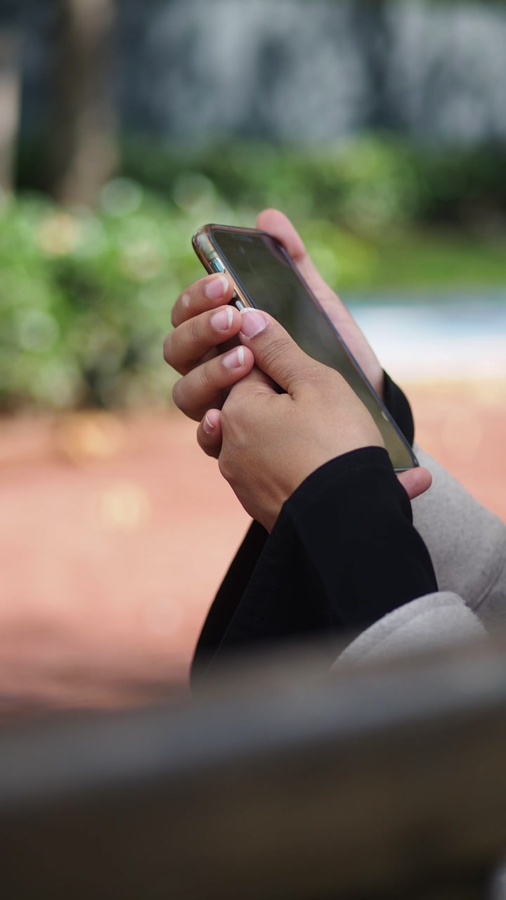 Close-up of Hands Holding a Smartphone Outdoors