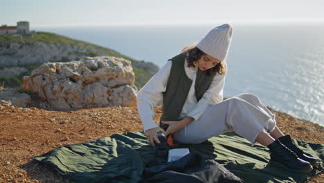 Chica-De-Picnic-Sirviendo-Café-En-El-Borde-Del-Acantilado-Vertical.-Océano-De-Descanso-Turístico-Despreocupado