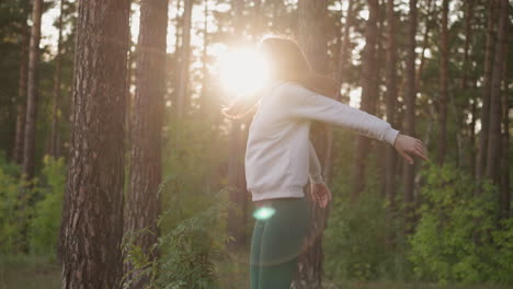 woman standing in the forest, enjoying the sun