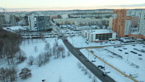 Los-Coches-Se-Acercan-A-La-Intersección-En-La-Ciudad-Cubierta-De-Nieve-De-Przymorze,-Gdansk,-Polonia.