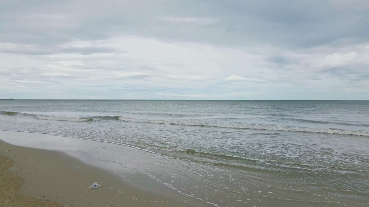 Cha Am Beach in Phetchaburi Thailand with Waves Rolling Over Sand.