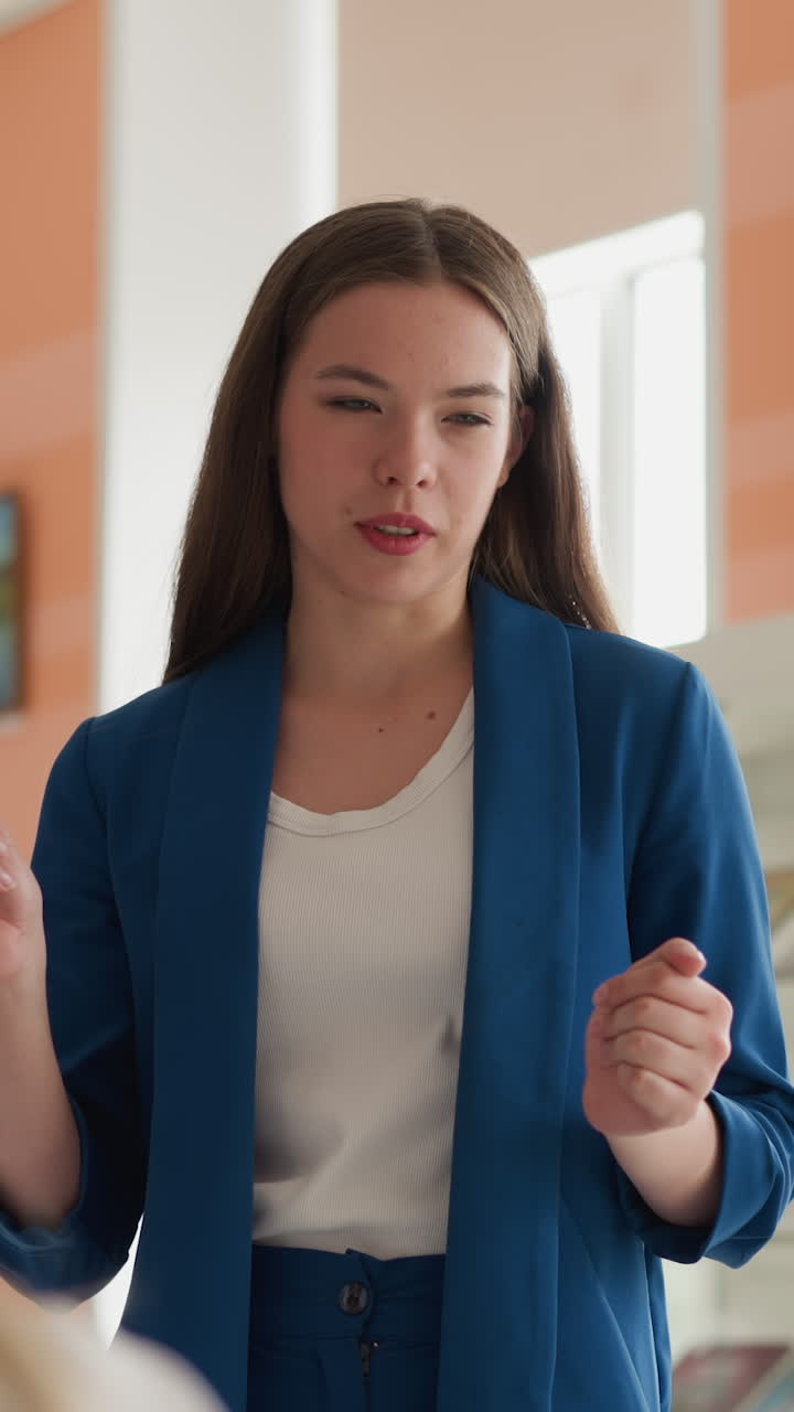 mujer da una lección en la biblioteca pública. joven conferenciante con pluma actúa ante la audiencia en la sala de lectura de la universidad. actividad educativa para estudiantes