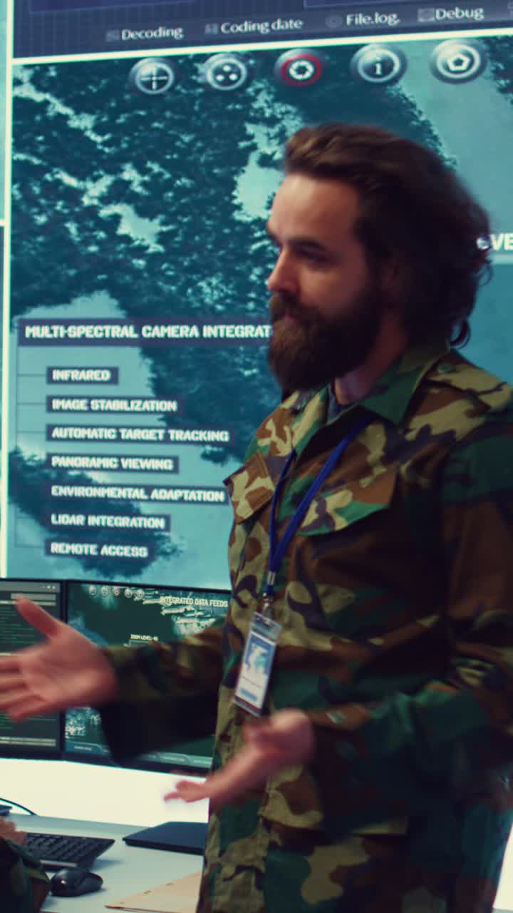 Soldat i camouflageuniform diskuterer data i kontrolrum