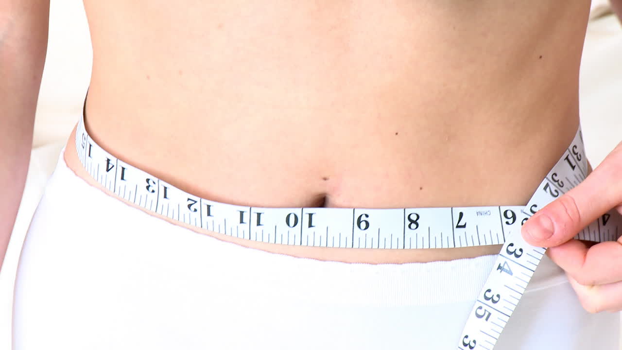 Young woman with a tape measure