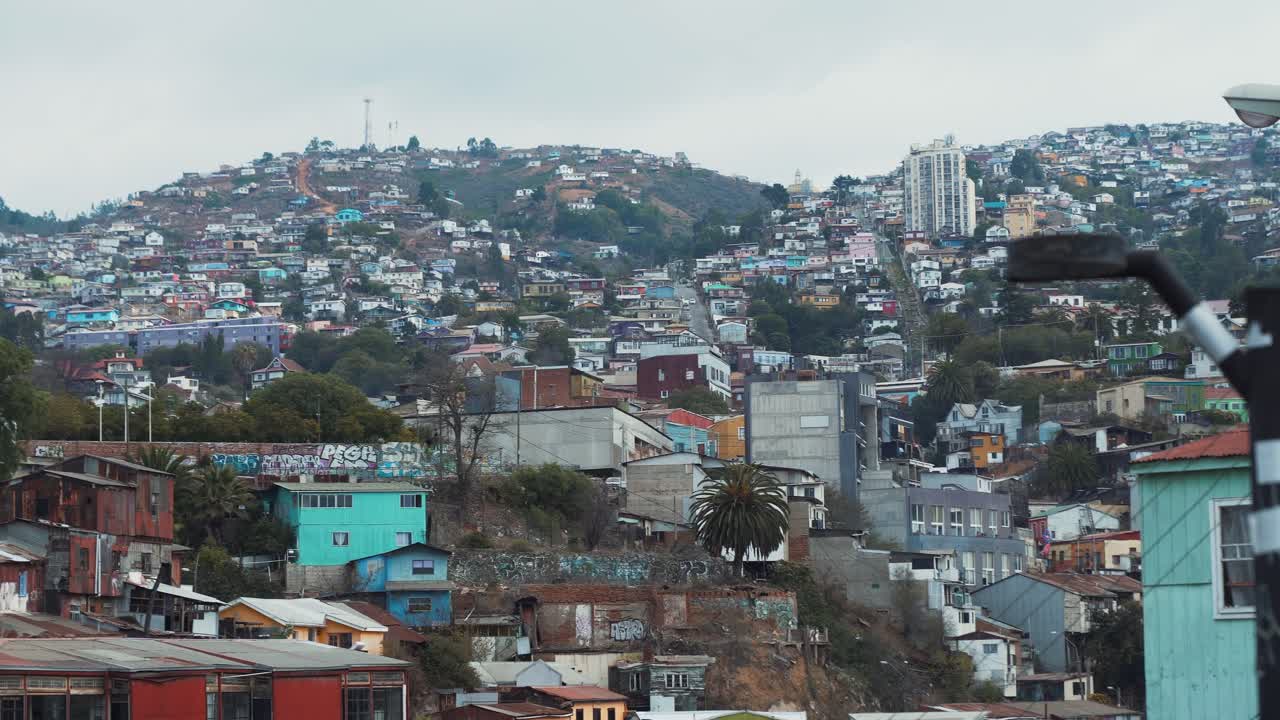 Un camion sulla destra con vista panoramica della città colorata dal Parco Culturale di Valparaiso a Cerro Carcel in una giornata nuvolosa, Cile.