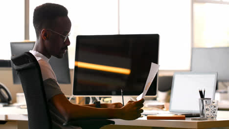 Male-executive-checking-document-at-desk-4k