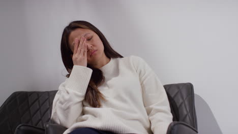 unhappy woman suffering with depression and anxiety sitting in reception of doctor or mental health worker 9