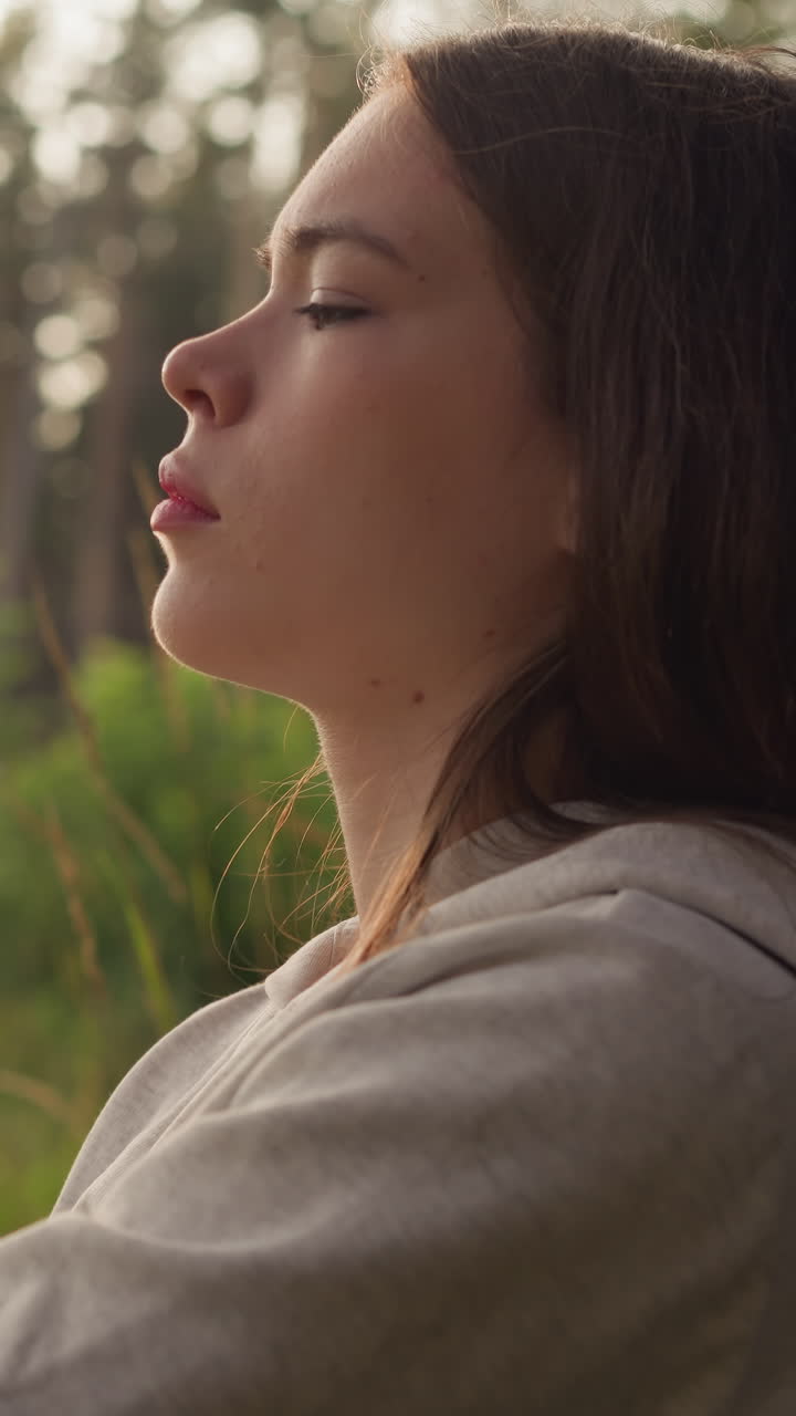 mujer piensa con los ojos cerrados apoyándose en el tronco del árbol al atardecer. señora deprimida considerando psicología ayuda a hacer frente al estrés en la atmósfera tranquila de la noche en la naturaleza