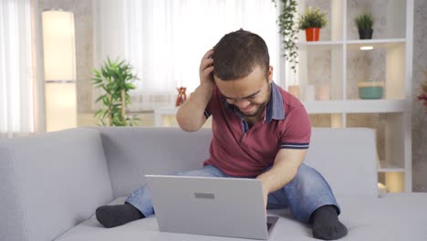 joven con enanismo trabaja en línea desde casa en una computadora portátil.