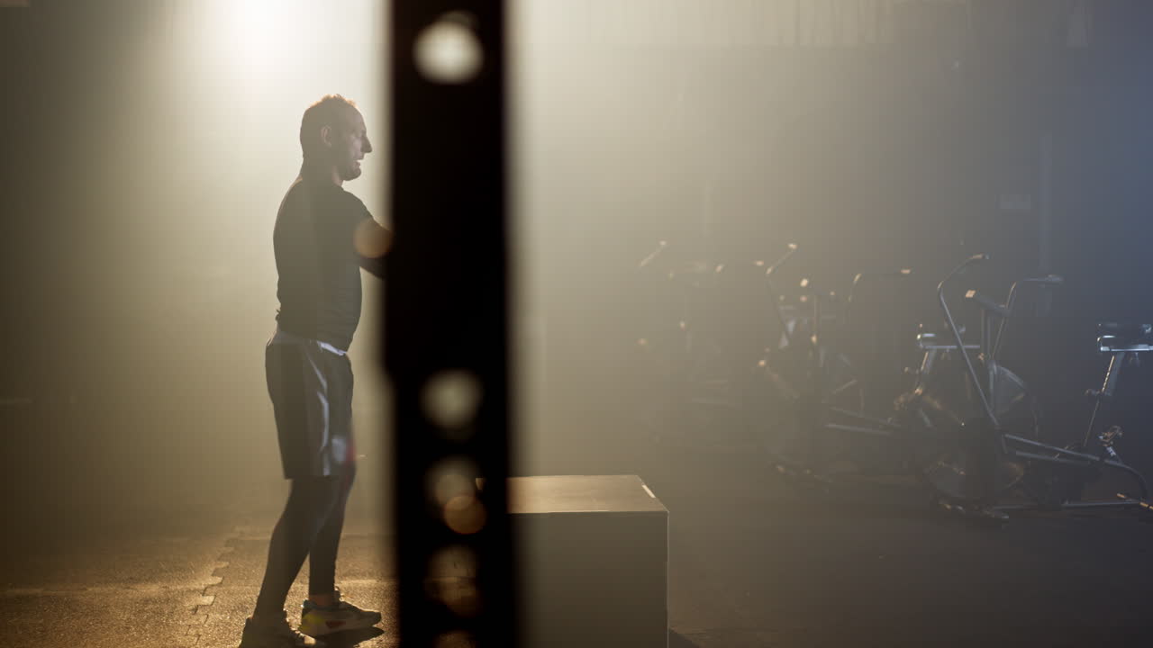 Man Doing Box Jumps in Foggy Gym