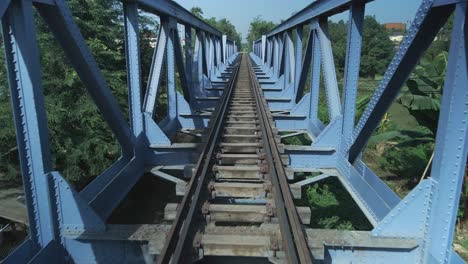 Railway-bridge,-symmetrical-structure-drone-fly-through,-track-view