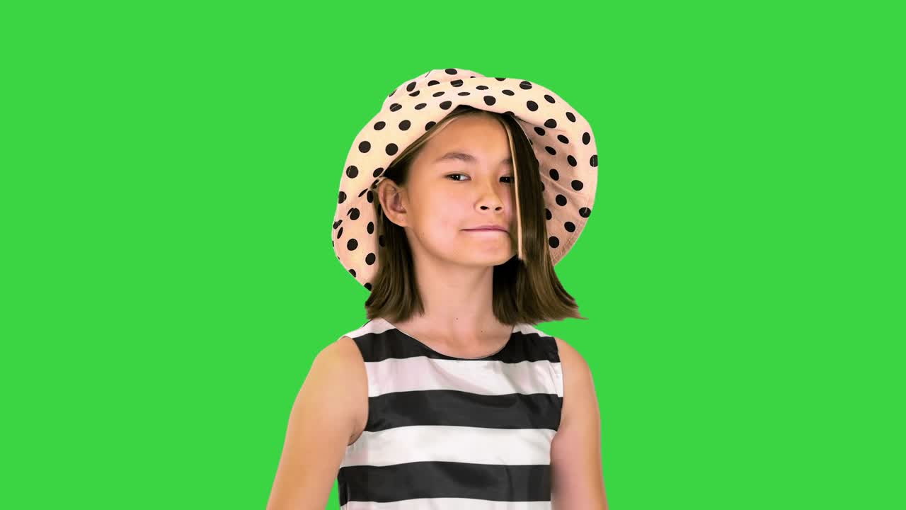 niña de verano en vestido de verano y un sombrero en una pantalla verde, clave de croma