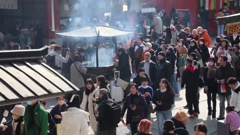 experience the vibrant energy of asakusa temple in tokyo, where visitors gather amidst traditional architecture and cultural rituals. a snapshot of life at one of japan’s most iconic spiritual sites