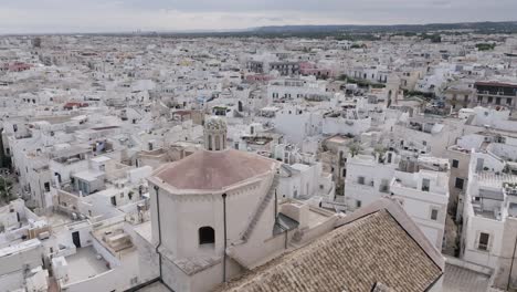 Imágenes-Aéreas-En-La-Ciudad-De-Polignano,-Una-Yegua-Volando-Hacia-La-Cúpula-De-Mosaico-De-Una-Iglesia.