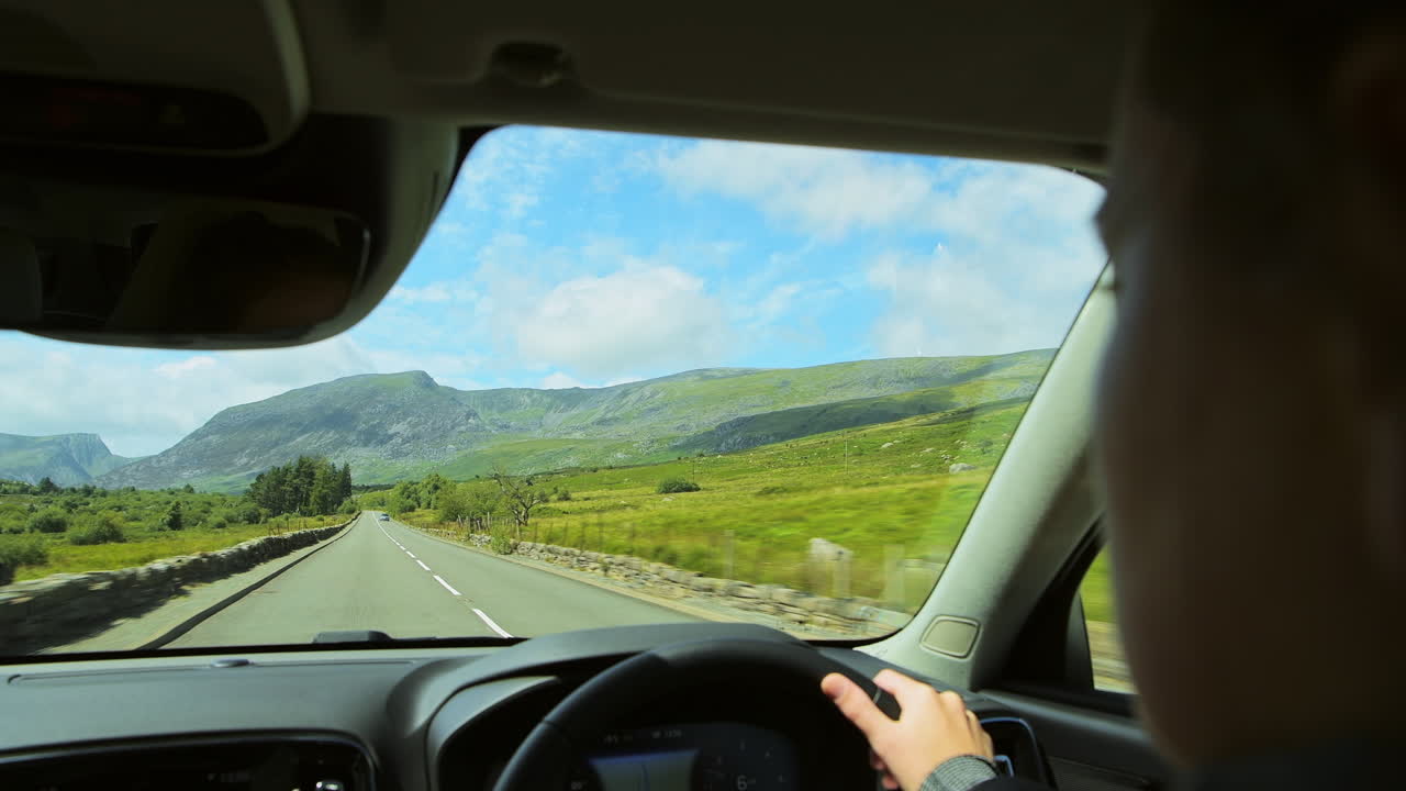Beautiful Nature Scenery While Driving A Car On The Asphalt Road In Snowdonia National Park, UK On A Sunny Day - rolling shot