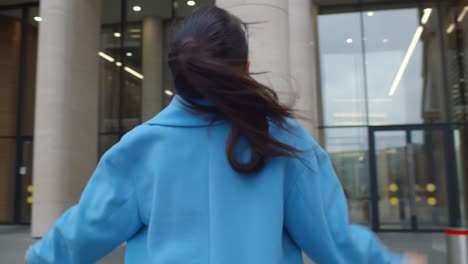 happy businesswoman doing winner gesture celebrating success standing outdoors on street