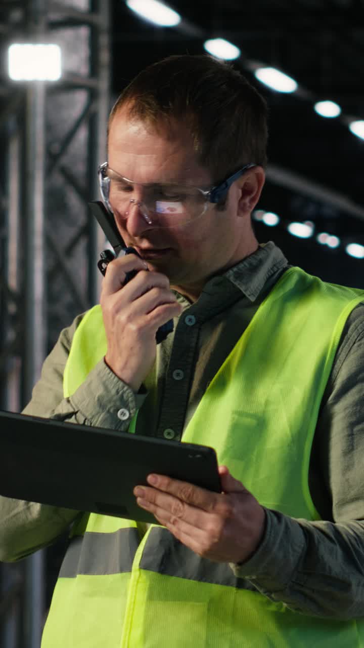 Vertical Video Employee speaking through walkie talkie radio to oversee machinery operation