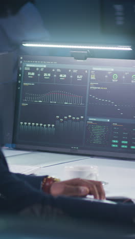 persona que trabaja en una computadora con pantallas de datos