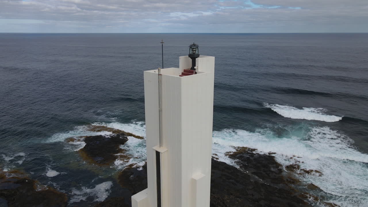 Aerial view of the modern Punta Hidalgo lighthouse on the rocky coast of Tenerife, Canary Islands