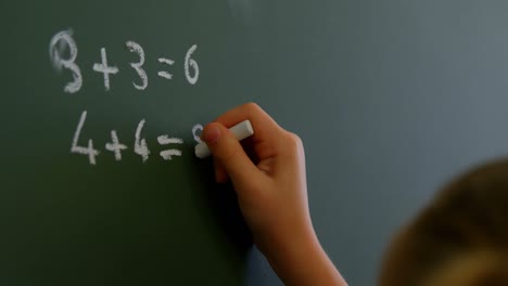 Schulmädchen-Schreibt-Mit-Kreide-Im-Klassenzimmer-Der-Schule-4k-Auf-Die-Tafel