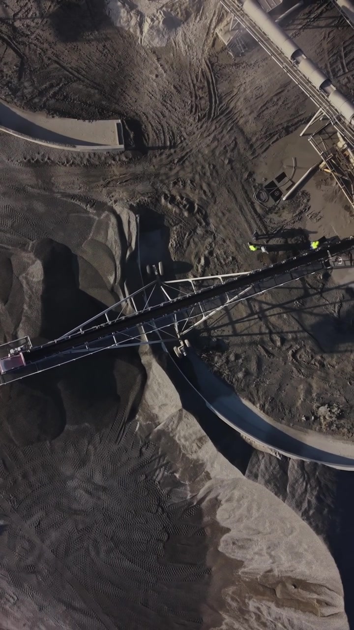 Operations at a quarry site showing machinery and mined materials