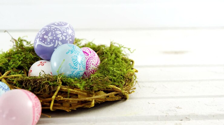 Painted Easter eggs in the nest on wooden surface