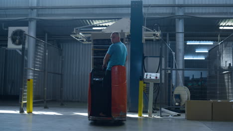 man operating storage truck moving production boxes managing warehouse delivery