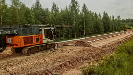 de la construcción de un camino de tierra forestal por parte de trabajadores con el lapso de tiempo de la máquina de prensado de hormigón