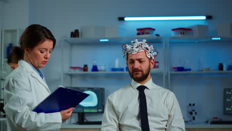 researcher neurologist asking man's symptoms taking notes on clipboard