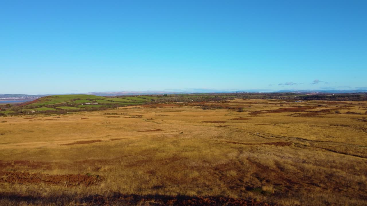 Rising View Over Gower Landscape with Farmed Fields in Background. Open Moorland with Trails Capturing Natural Beauty of Surrounding Countryside. South Wales, UK