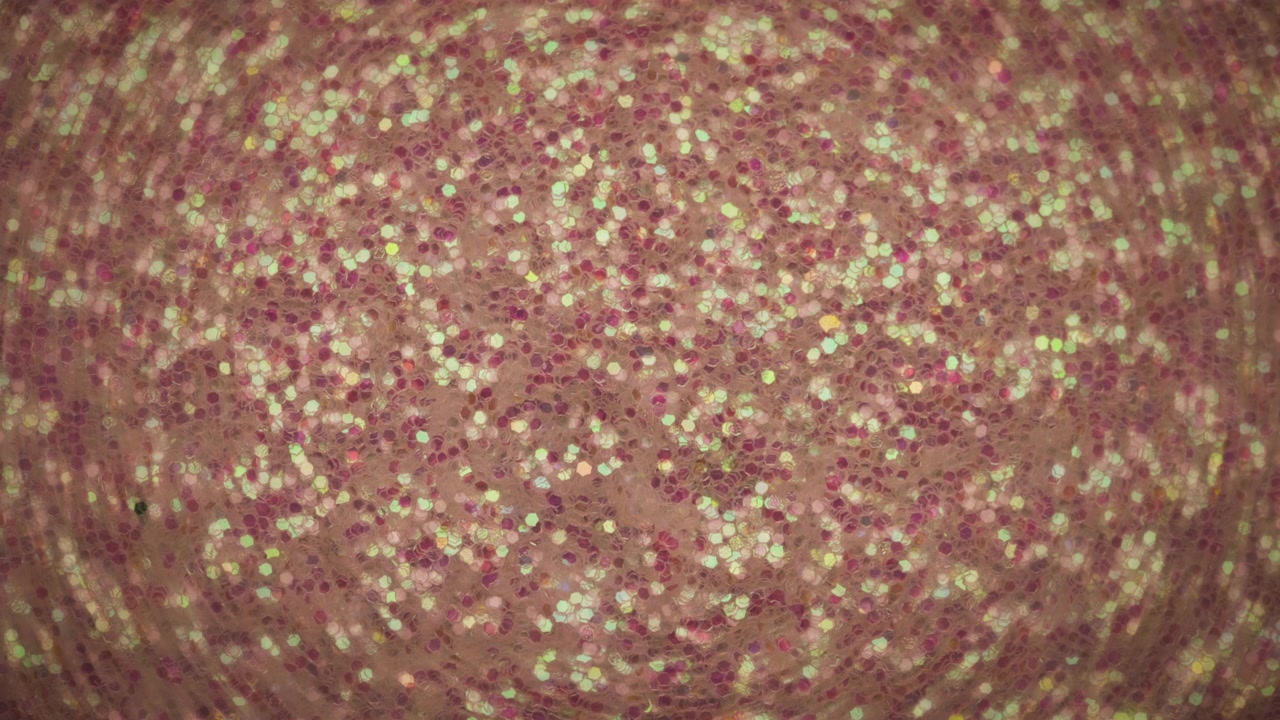 Valo paistaa värikkään glitterin yllä. Abstrakti tausta.