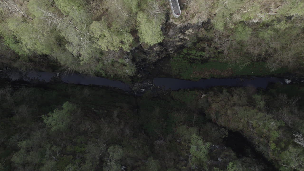vista aérea de drones de arriba hacia abajo de la estrecha garganta de corrieshalloch rodeada de bosque en las tierras altas escocesas