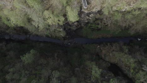 Top-down-view-aerial-drone-shot-of-narrow-Corrieshalloch-gorge-surrounded-by-forest-in-Scottish-Highlands