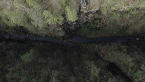 Vista-De-Arriba-Hacia-Abajo-Toma-Aérea-De-Drones-Del-Estrecho-Desfiladero-De-Corrieshalloch-Rodeado-De-Bosque-En-Las-Tierras-Altas-Escocesas