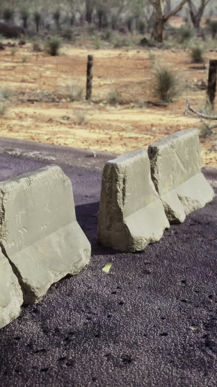 Road barriers disrupt traffic in a remote desolate landscape
