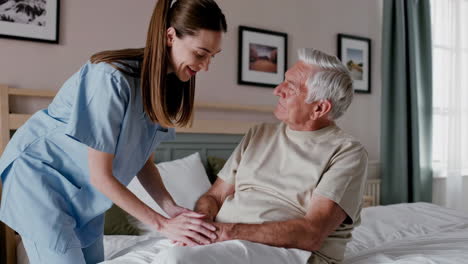 a caregiver assisting an elderly man in a bedroom