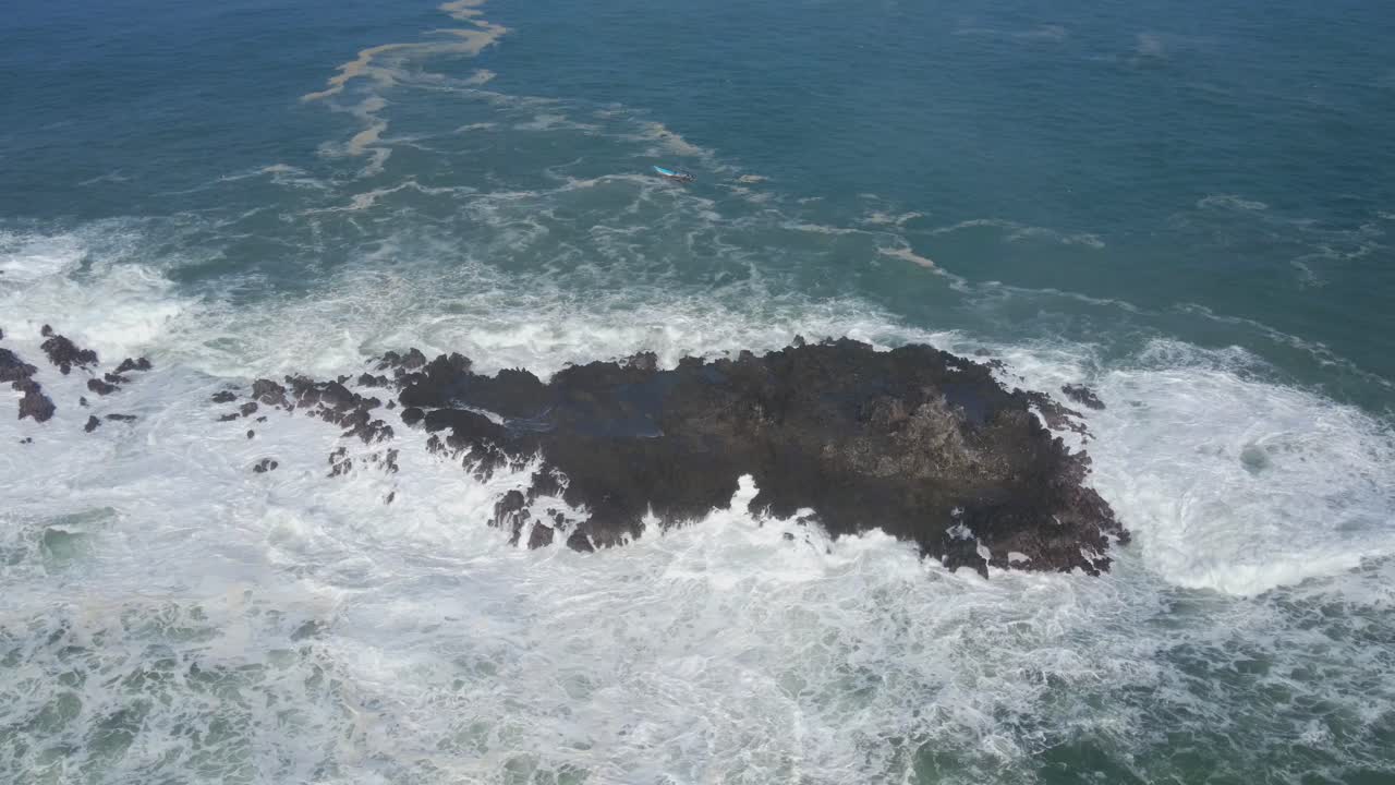 olas del océano golpeando isla rocosa, poder del mar, vista de órbita aérea