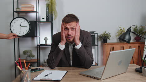 Hombre-De-Negocios-Trabajando-En-Una-Computadora-Portátil-En-La-Oficina-Con-Ansiedad-Comprobando-El-Tiempo-En-El-Reloj-Retrasado,-Fecha-Límite