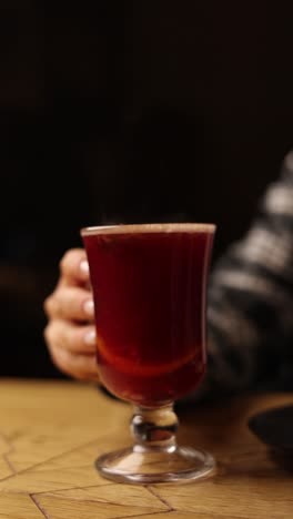 woman holding a glass of warm spiced wine