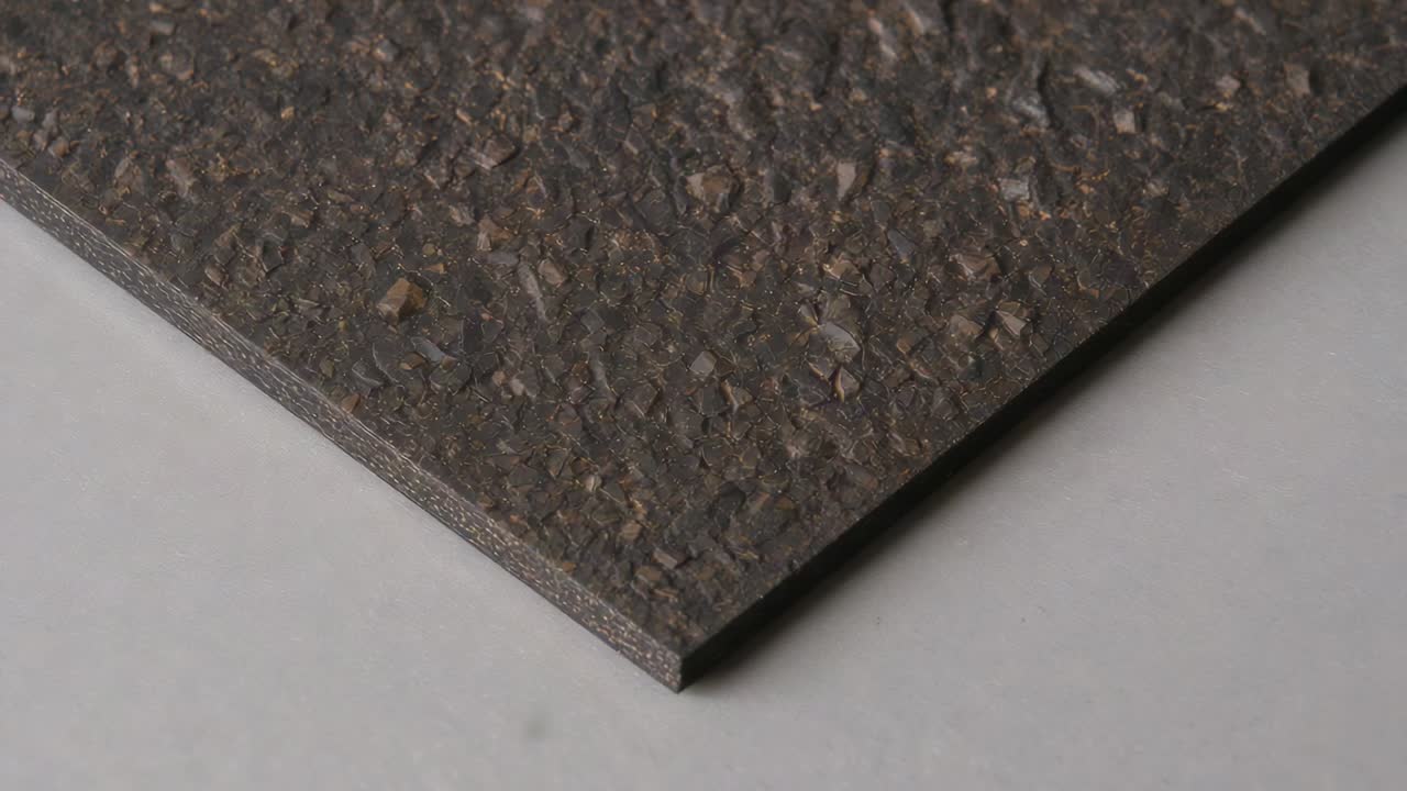 Falling fine granules settling on textured rectangular panel at work table, forming light gradient
